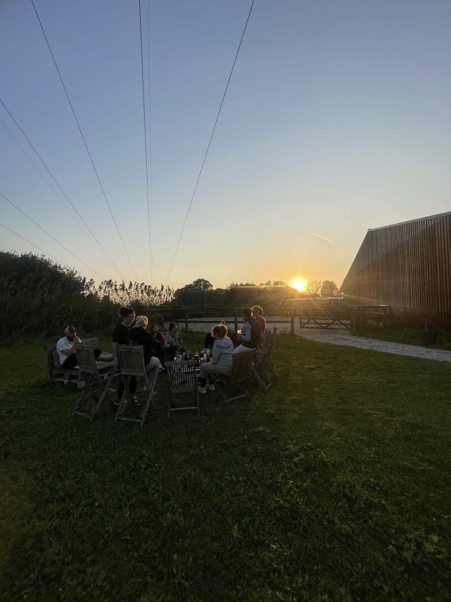 Cavaliers réunis autour de tables dans l'herbe au coucher du soleil.