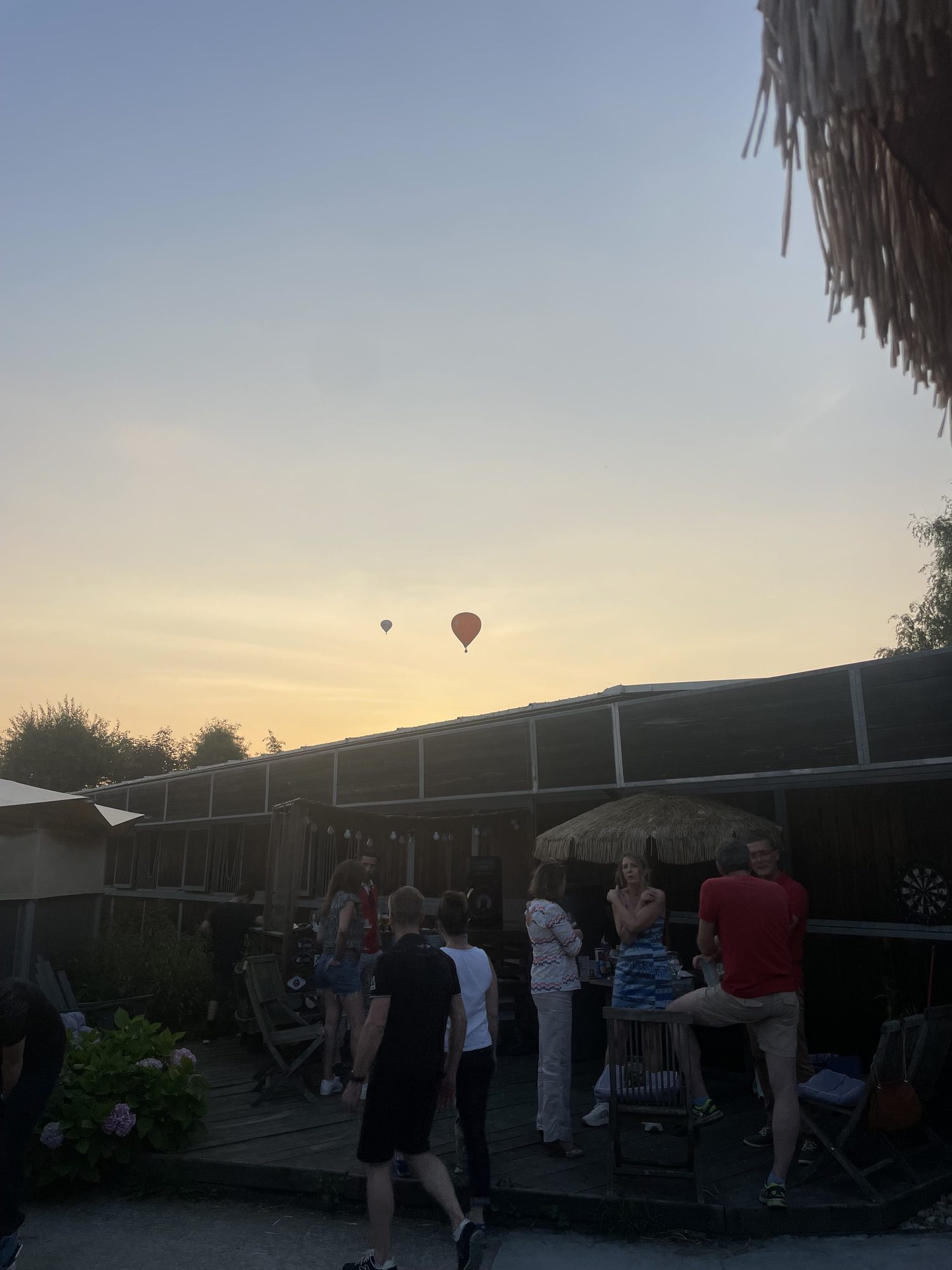 Montgolfières dans le ciel au coucher du soleil au-dessus de la terrasse de l'écurie.